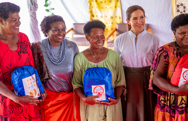 The ED stands, smiling with four other women